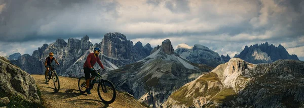 Cycling outdoor adventure in Dolomites. Cycling woman and man  o — Stock Photo, Image
