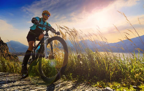 Cykling utomhus tillbehör.Mountainbike kvinna vid soluppgången över — Stockfoto