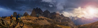 Dolomitlerde bisiklet macerası. Dolomitler 'de bisikletli kadın ve erkek bisikletli. Birkaç bisikletli Mtb enduro patikası. Açık hava sporları aktivitesi.