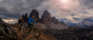 Dolomitlerde bisiklet macerası. Dolomitler 'de bisikletli kadın ve erkek bisikletli. Birkaç bisikletli Mtb enduro patikası. Açık hava sporları aktivitesi.