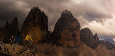Dolomitlerde bisiklet macerası. Dolomitler 'de bisikletli kadın ve erkek bisikletli. Birkaç bisikletli Mtb enduro patikası. Açık hava sporları aktivitesi.