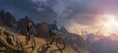 Dolomitlerde bisiklet macerası. Dolomitler 'de bisikletli kadın ve erkek bisikletli. Birkaç bisikletli Mtb enduro patikası. Açık hava sporları aktivitesi.