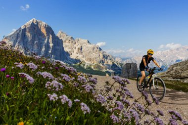 Dolomitlerde bisiklet macerası. Dolomitler 'de bisiklet süren bir kadın. Mtb enduro patikasında bisiklet süren bir kadın. Açık hava sporları aktivitesi.