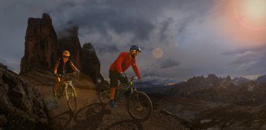 Dolomitlerde bisiklet macerası. Dolomitler 'de bisikletli kadın ve erkek bisikletli. Birkaç bisikletli Mtb enduro patikası. Açık hava sporları aktivitesi.