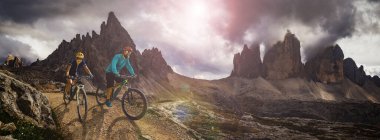 Dolomitlerde bisiklet macerası. Dolomitler 'de bisikletli kadın ve erkek bisikletli. Birkaç bisikletli Mtb enduro patikası. Açık hava sporları aktivitesi.