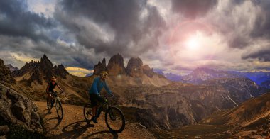 Dolomitlerde bisiklet macerası. Dolomitler 'de bisikletli kadın ve erkek bisikletli. Birkaç bisikletli Mtb enduro patikası. Açık hava sporları aktivitesi.