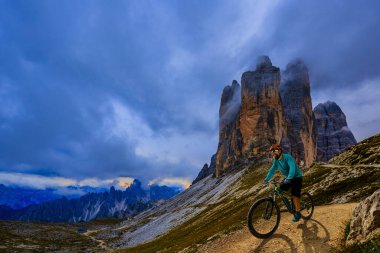Elektrikli bisikletteki adam bisikleti, dağ izini sürmek. Adam Dolomitler dağlar manzara bisiklet sürme. Bisiklet e-MTB Enduro Trail parça. Açık spor aktivitesi.