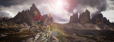 Dolomitlerde bisiklet macerası. Dolomitler 'de bisikletli kadın ve erkek bisikletli. Birkaç bisikletli Mtb enduro patikası. Açık hava sporları aktivitesi.