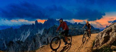 Dolomitlerde bisiklet macerası. Dolomitler 'de bisikletli kadın ve erkek bisikletli. Birkaç bisikletli Mtb enduro patikası. Açık hava sporları aktivitesi.