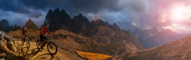 Dolomitlerde bisiklet macerası. Dolomitler 'de bisikletli kadın ve erkek bisikletli. Birkaç bisikletli Mtb enduro patikası. Açık hava sporları aktivitesi.