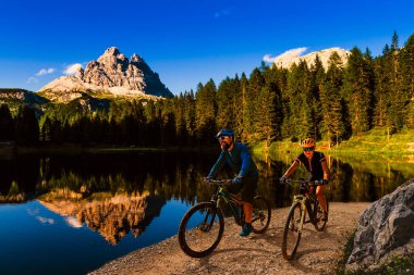 Dolomitlerde bisiklet macerası. Dolomitler 'de bisikletli kadın ve erkek bisikletli. Birkaç bisikletli Mtb enduro patikası. Açık hava sporları aktivitesi.