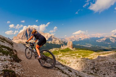 Dolomitlerde bisiklet macerası. Dolomitler 'de bisiklet süren bir kadın. Mtb enduro patikasında bisiklet süren bir kadın. Açık hava sporları aktivitesi.