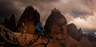 Dolomitlerde bisiklet macerası. Dolomitler 'de bisikletli kadın ve erkek bisikletli. Birkaç bisikletli Mtb enduro patikası. Açık hava sporları aktivitesi.