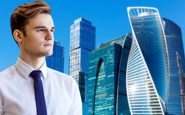 Young businessman over cityscape and blue sky background. — Stock Photo, Image