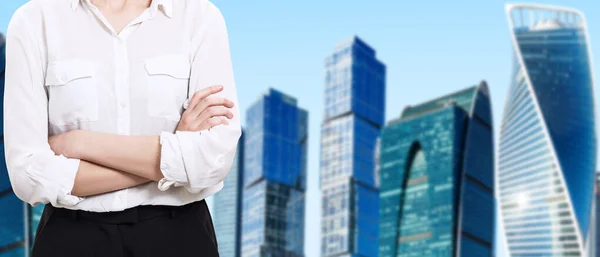 Zakelijke vrouw in witte blouse staat over stadsgezicht achtergrond. — Stockfoto