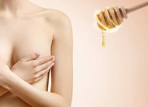Wanita muda menutupi payudara dengan tangan dekat honney sendok. — Stok Foto