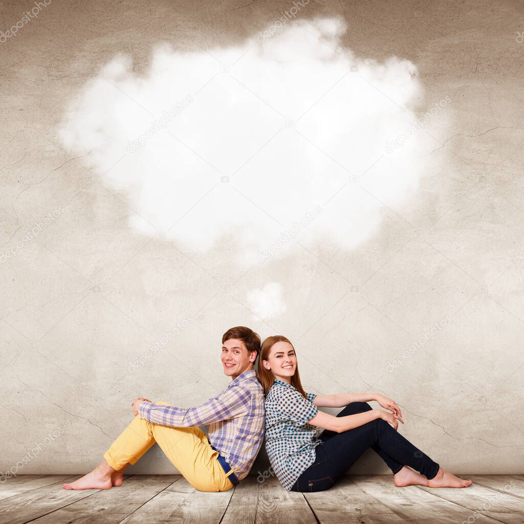 Happy couple sitting on the floor with white cloud above the head.