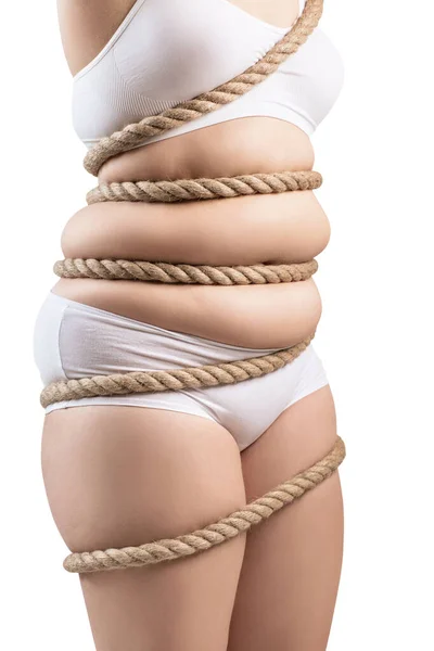 Mulher gorda em roupa interior branca torcida com uma corda . — Fotografia de Stock