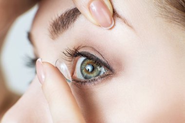 Kontakt lens takan genç bir kadının yakın plan fotoğrafı..