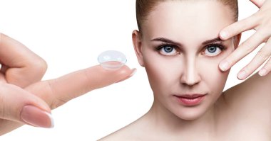 Güzel bir kadın yüzünün yakınındaki işaret parmağında kontakt lens.