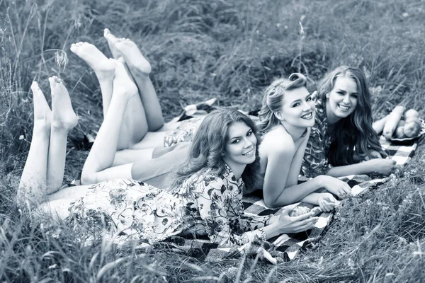 Jóvenes mujeres hermosas tumbadas en cuadros en el parque de verano . — Foto de Stock