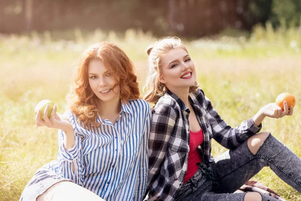 Fiatal gyönyörű nők piknikeznek a nyári parkban. — Stock Fotó