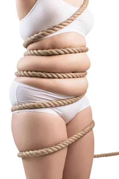 Mulher gorda em roupa interior branca torcida com uma corda . — Fotografia de Stock