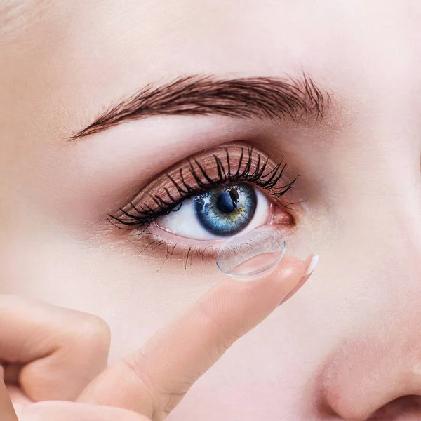 Contactlens op wijsvinger nabij blauw vrouwelijk oog. — Stockfoto