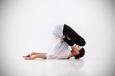 Yoga yapan genç bir kadın..