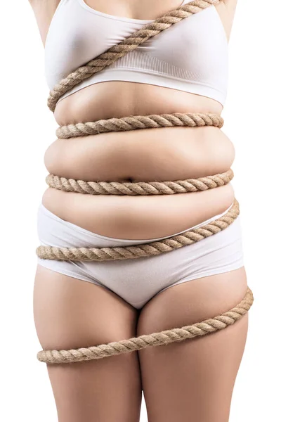 Mulher gorda em roupa interior branca torcida com uma corda . — Fotografia de Stock