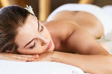 güzel bir genç kadın masaj masanın üzerinde yatan.