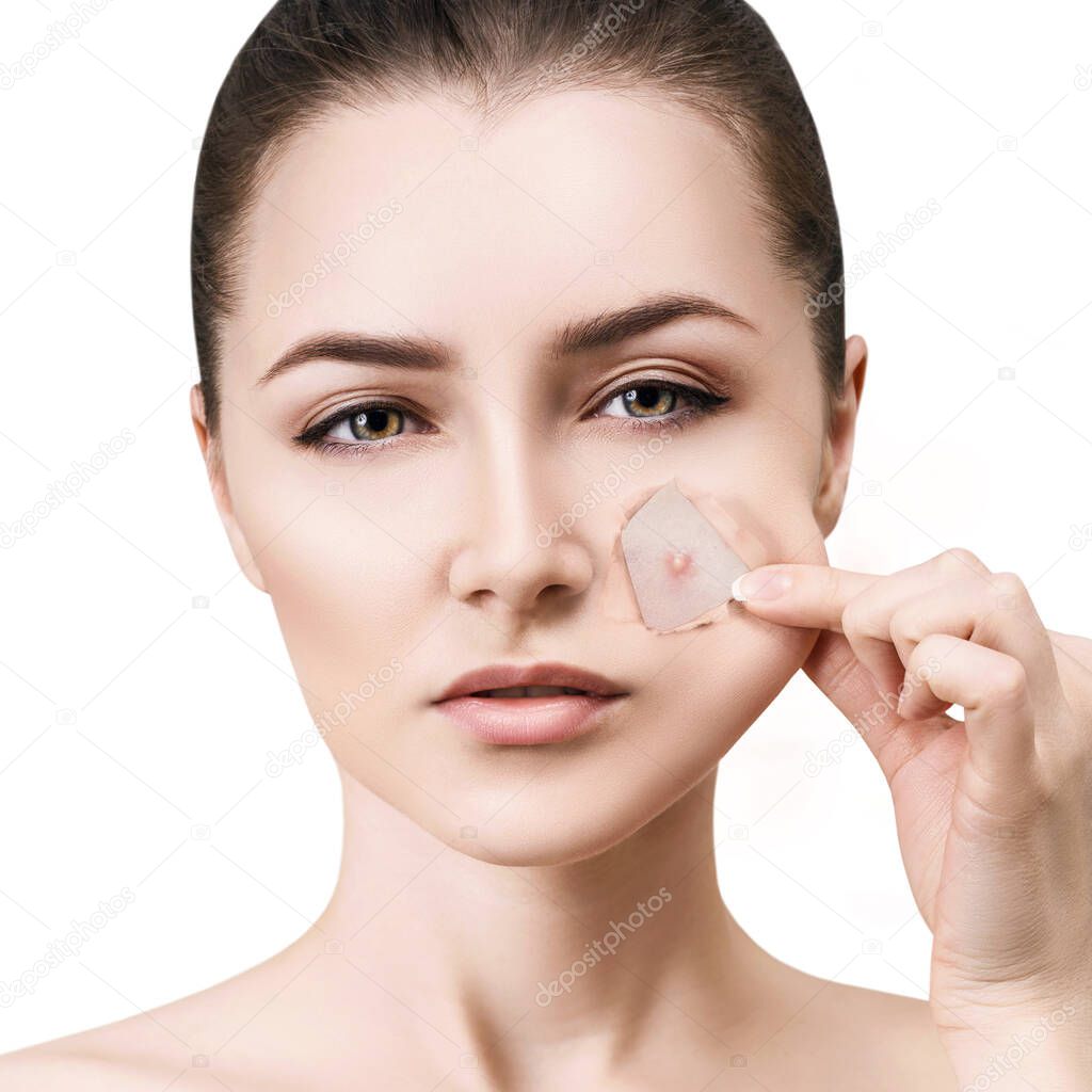 Woman with pimple on face peek from hole in foundation.