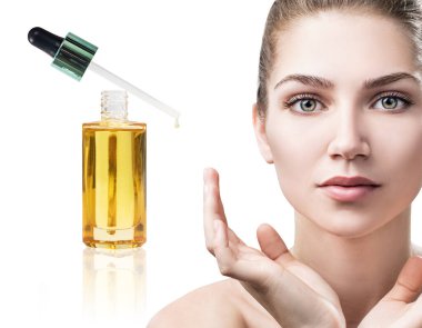 Kozmetik yağı genç bir kadının yüzüne sürülüyor..