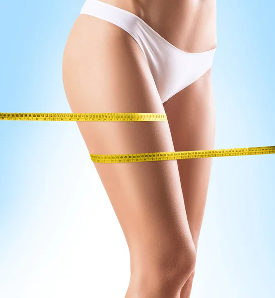 Female legs with measuring tape. — Stock Photo, Image