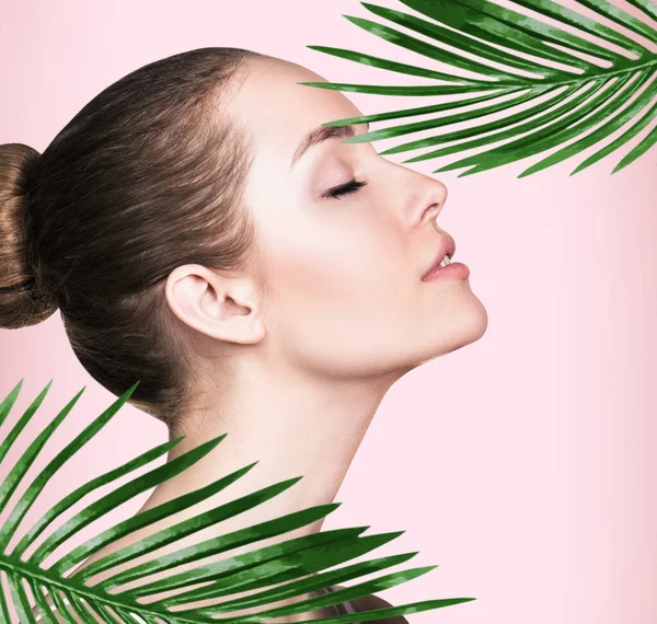 Vacker kvinna med perfekt hud bland palmblad. — Stockfoto
