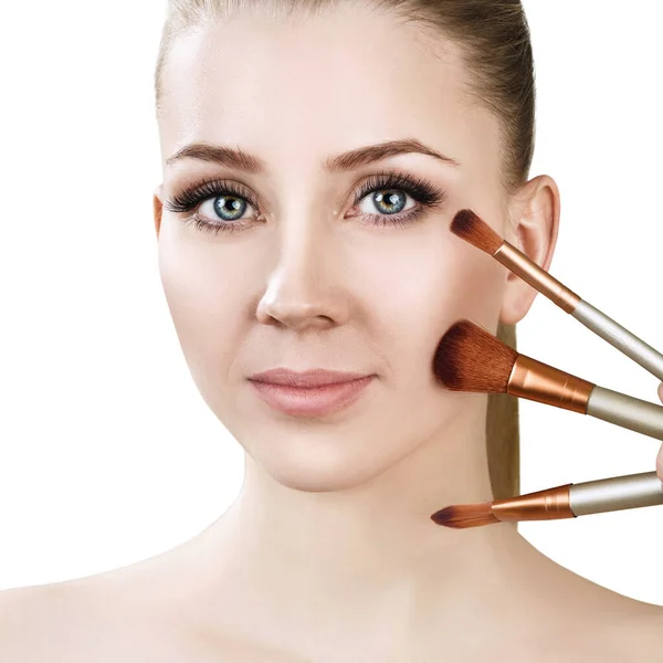 Mooie vrouw houdt make-up borstels in de buurt van het gezicht. — Stockfoto