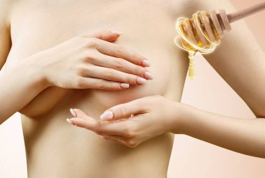 Genç bir kadın, honney kaşığının yanında göğsünü elleriyle kapatıyor..