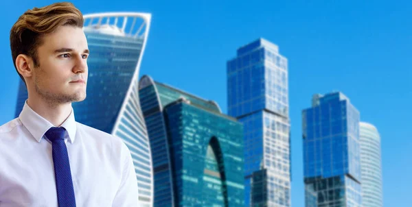 Young businessman over cityscape and blue sky background. — Stock Photo, Image