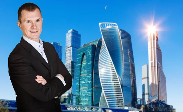 Businessman with crossed hands over cityscape background. — Stock Photo, Image