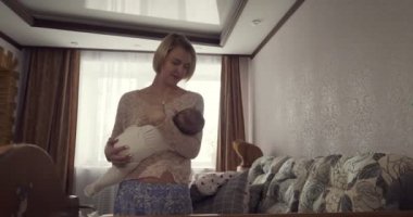 Genç anne bebeğini beşiğe koyar..