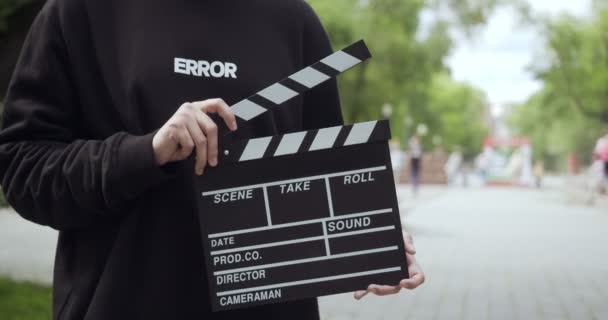 Unrecognizable man with clapperboard leaves the video frame. — Stockvideo