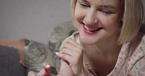 Mère tient les jambes de bébé dans les mains et embrasser . — Video