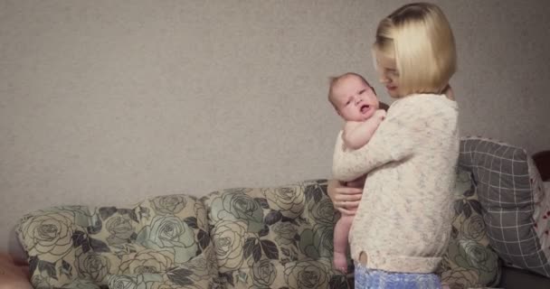 Young mother holds and calms her little baby girl. — Stock Video