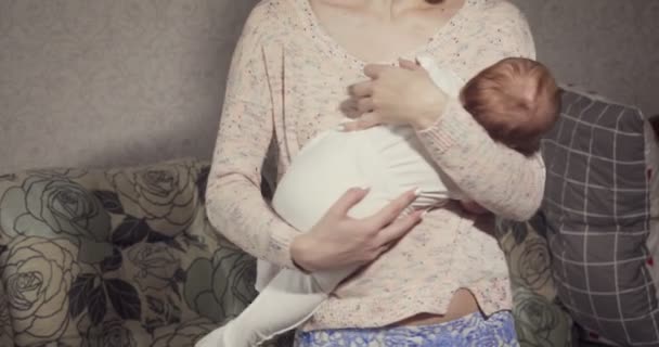 Joven madre pone a dormir a su pequeño bebé . — Vídeo de stock