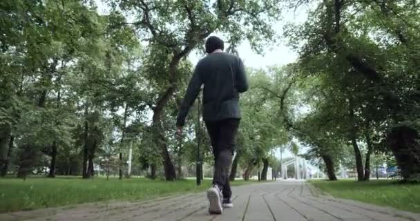 Visão traseira no homem ouve música do leitor de cassetes ao ar livre — Vídeo de Stock