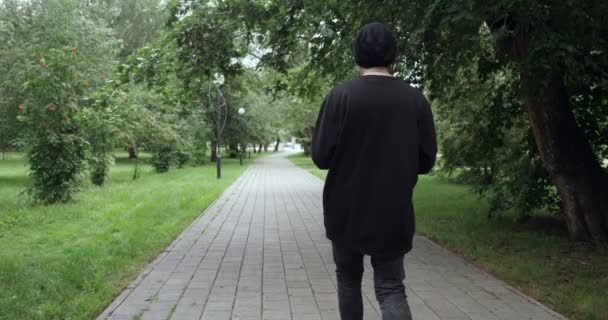 Rear view on man listens to music from cassette player outdoors — Stock Video