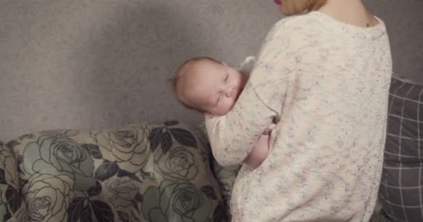 Молодая мать усыпляет своего малыша . — стоковое видео