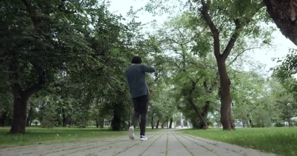 Вид сзади на человека слушает музыку из кассетного проигрывателя на открытом воздухе — стоковое видео