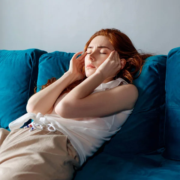 Mujer joven se siente mal y que sufre de dolor de cabeza en casa . — Foto de Stock