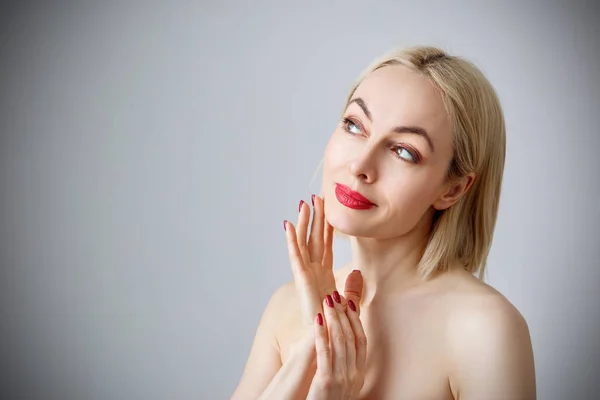 Mooie vrouw poseren over grijze achtergrond. — Stockfoto